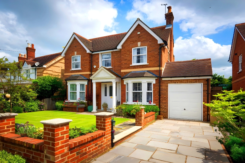 Front view of a detached house with a garage and front lawn